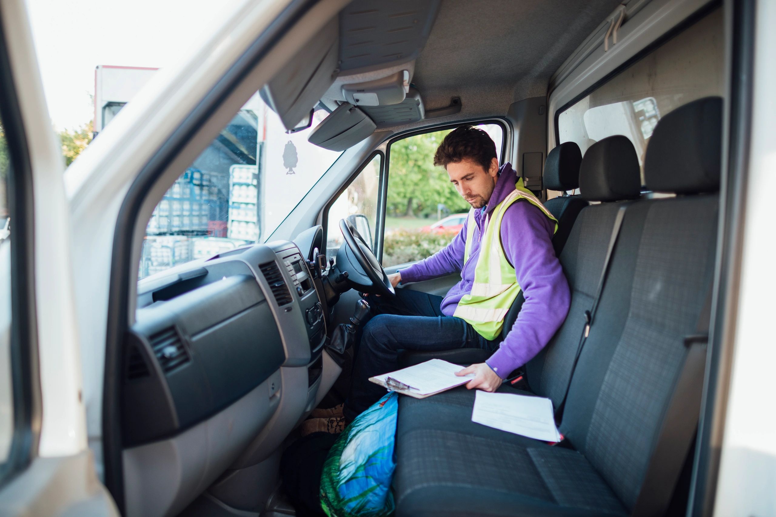 Delivery driver reviewing delivery notes in a van