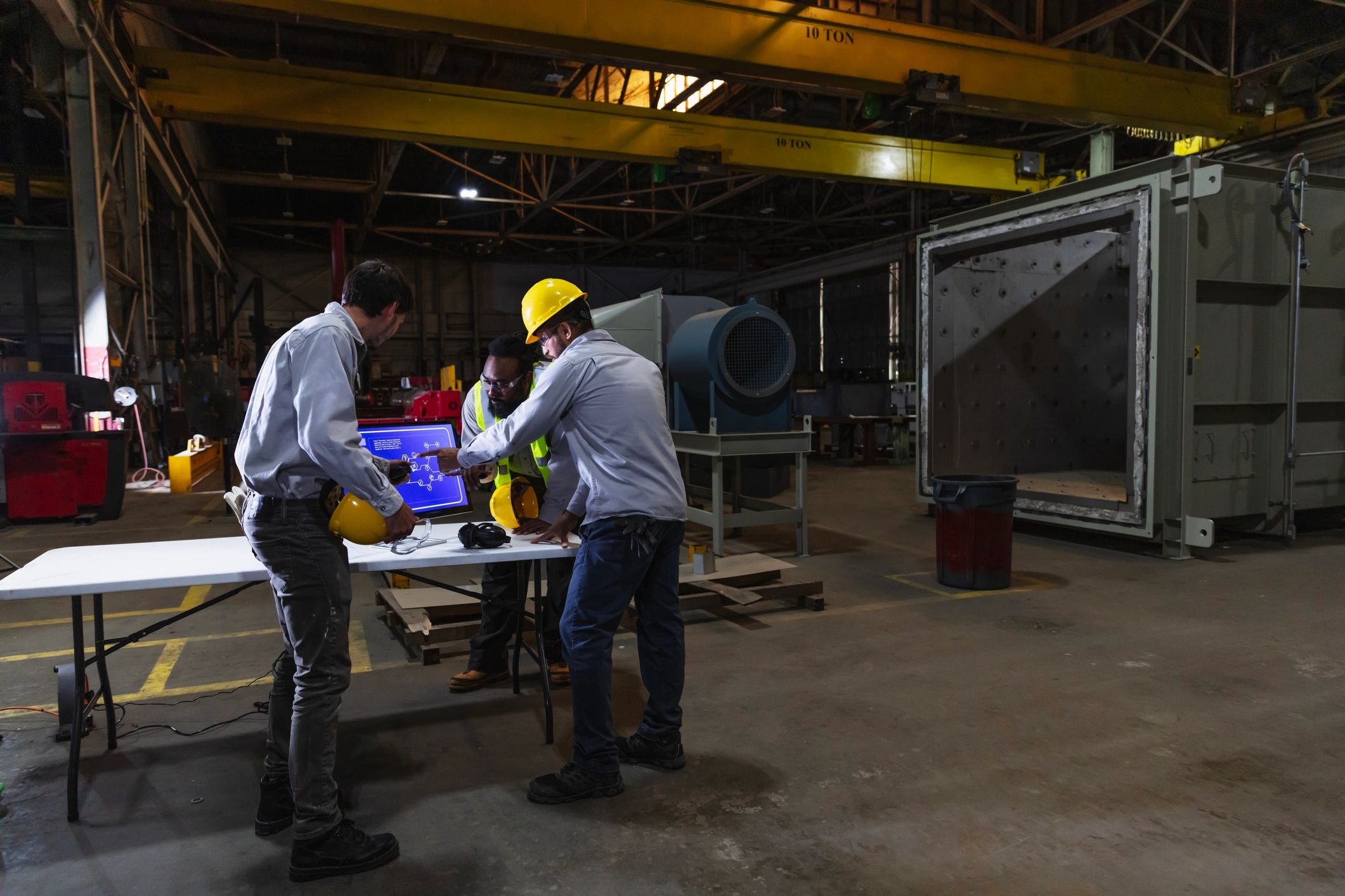 Engineering team reviewing a digital diagram on the factory floor