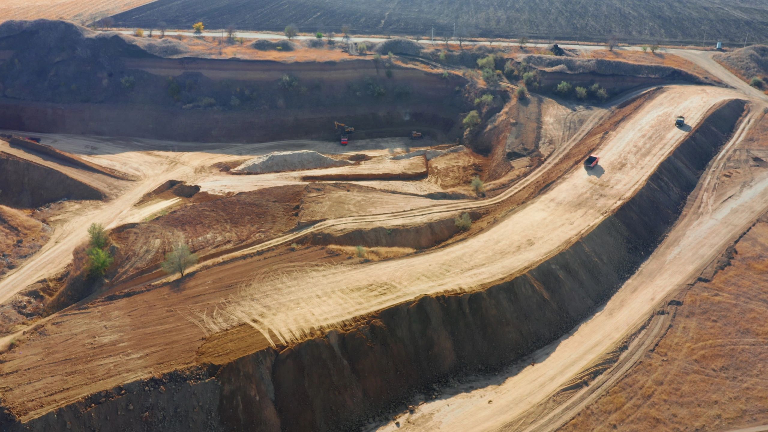 Aerial view of an open-pit mine with haul roads and heavy machinery