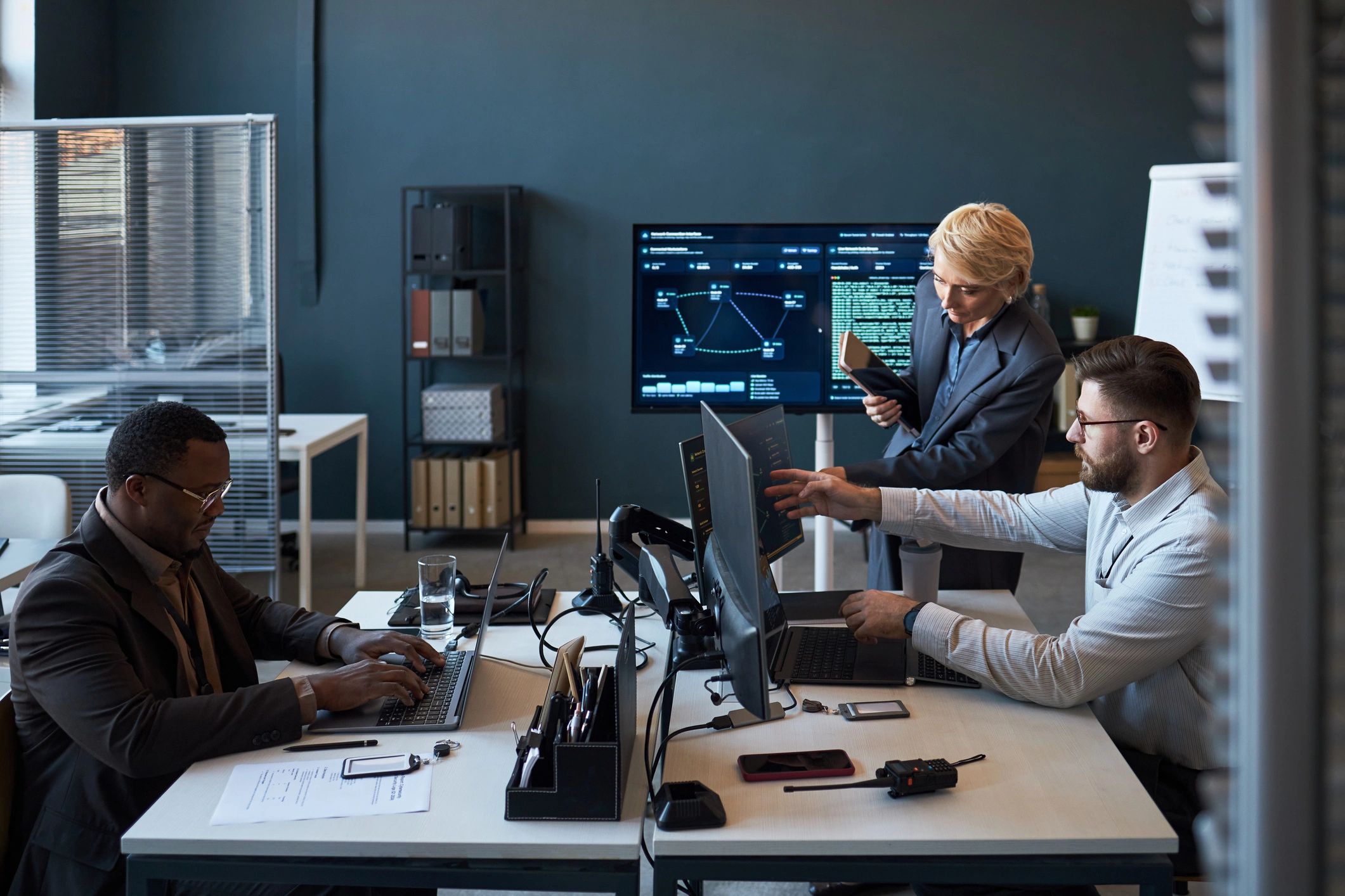 Business team reviewing cybersecurity and operational data dashboards