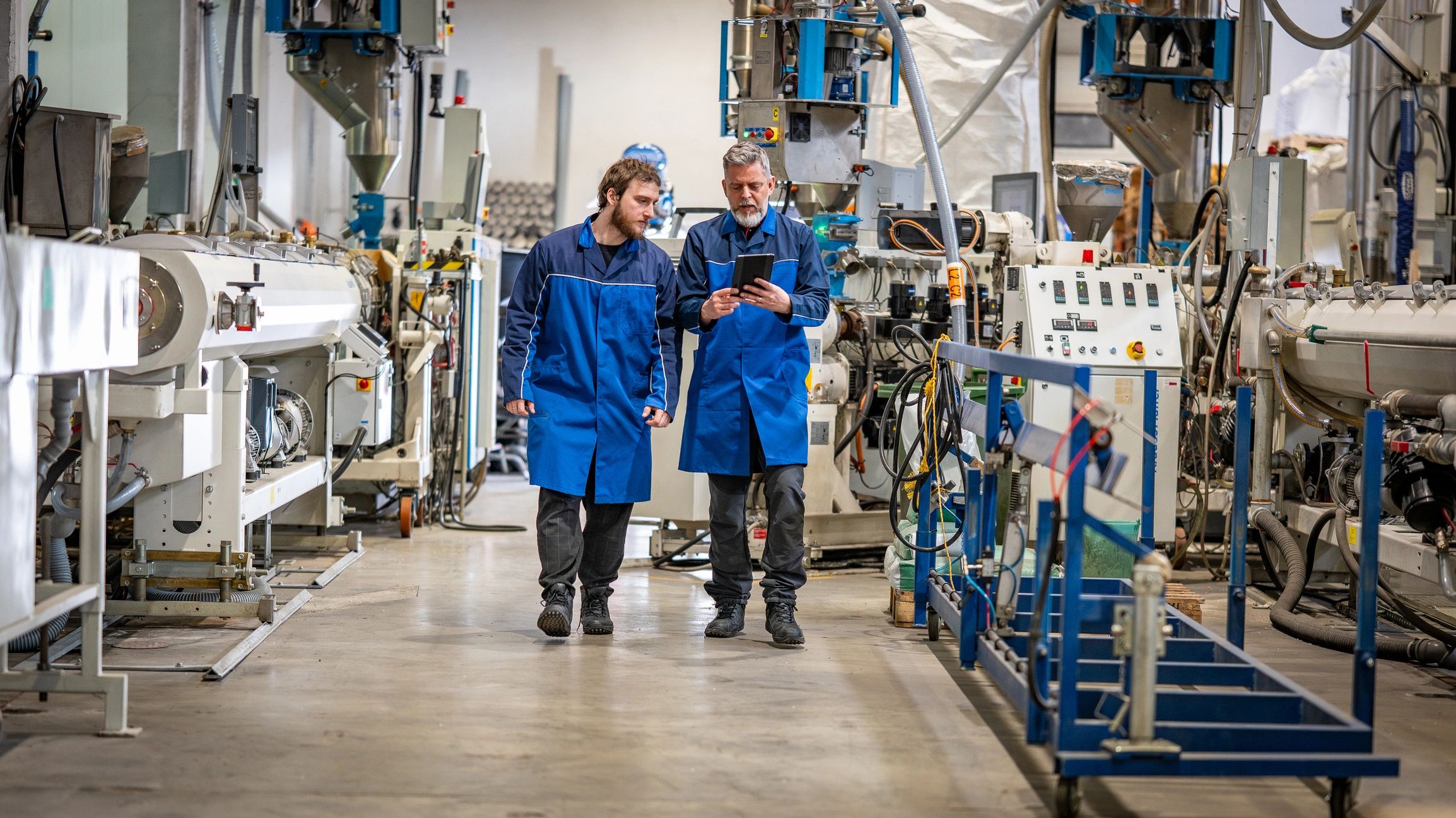 Engineers reviewing production data on a tablet in a high-tech factory